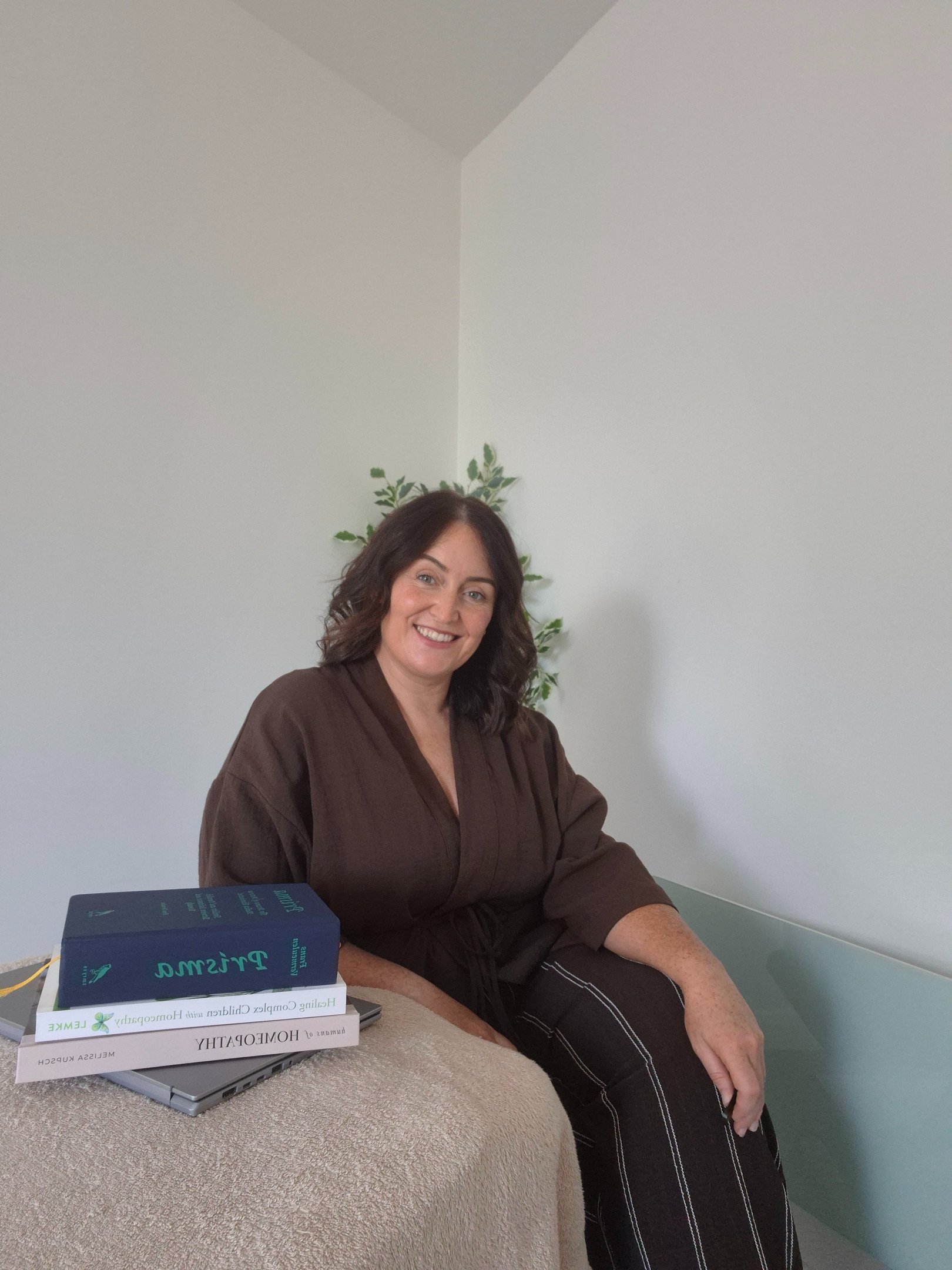 Lindsay Cleary sitting beside her homeopathy books